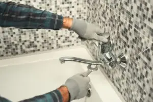 Plumber repairing a tap in the bathroom