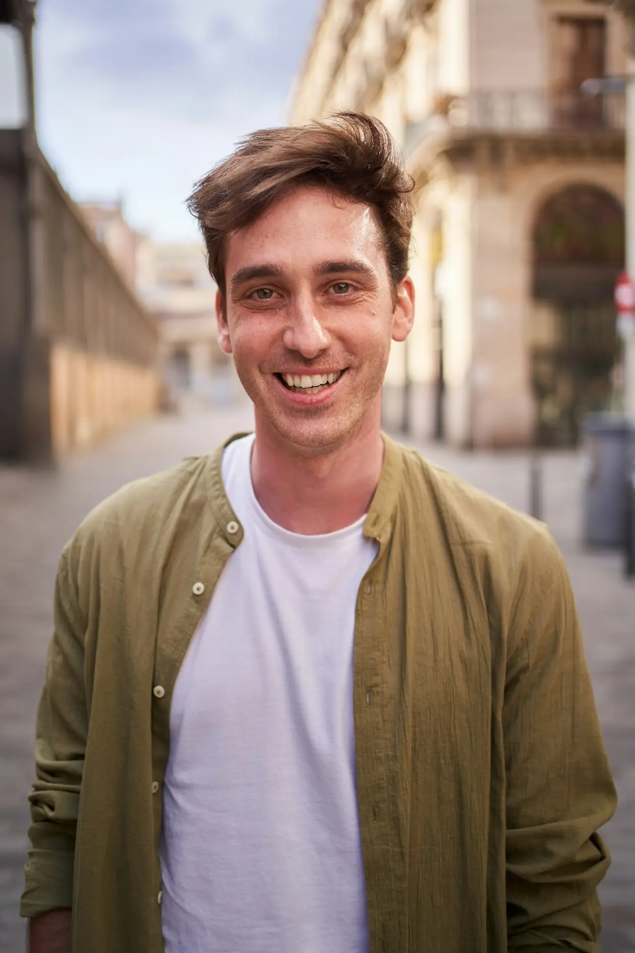 Vertical portrait of happy young European man happy smiling face on street. Male people cheerful.